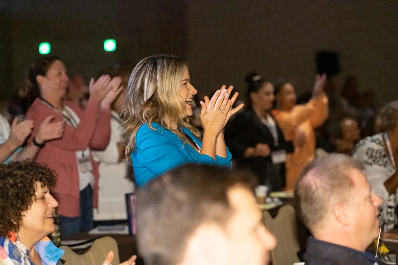 An energized group of law firm owners applauding at an HTM event.