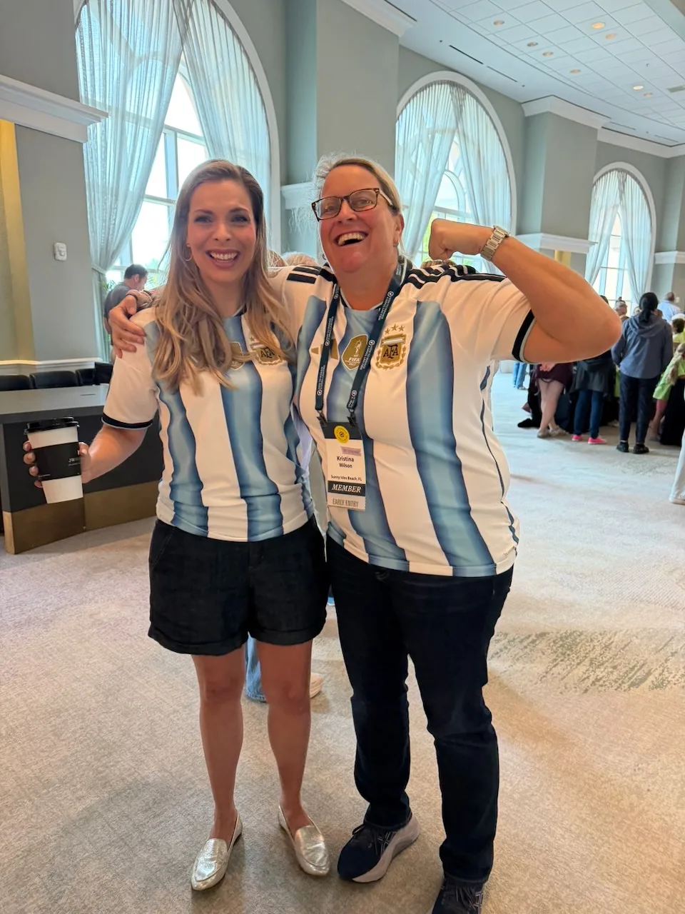 Two smiling HTM members celebrating together at a live event.