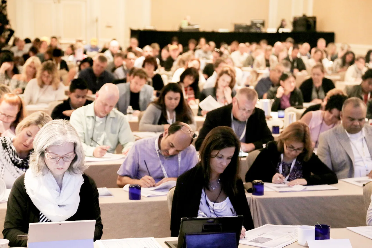 Workshop participants raising their hands together during a group exercise.