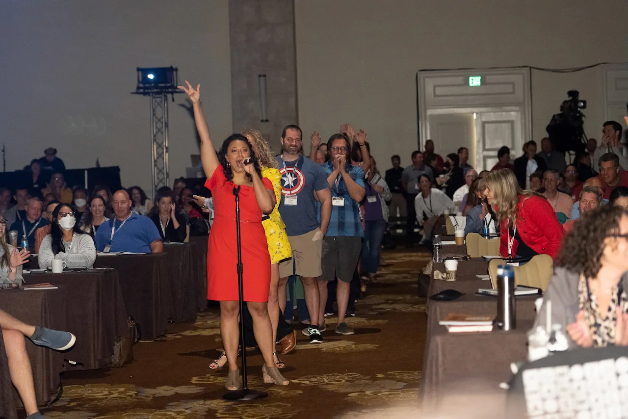 Law firm owners smiling and raising their hands during an energetic HTM member exercise.
