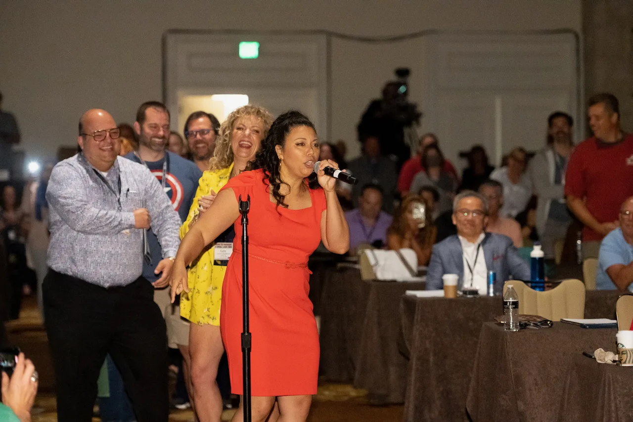 An HTM facilitator leading an energetic room-wide exercise.