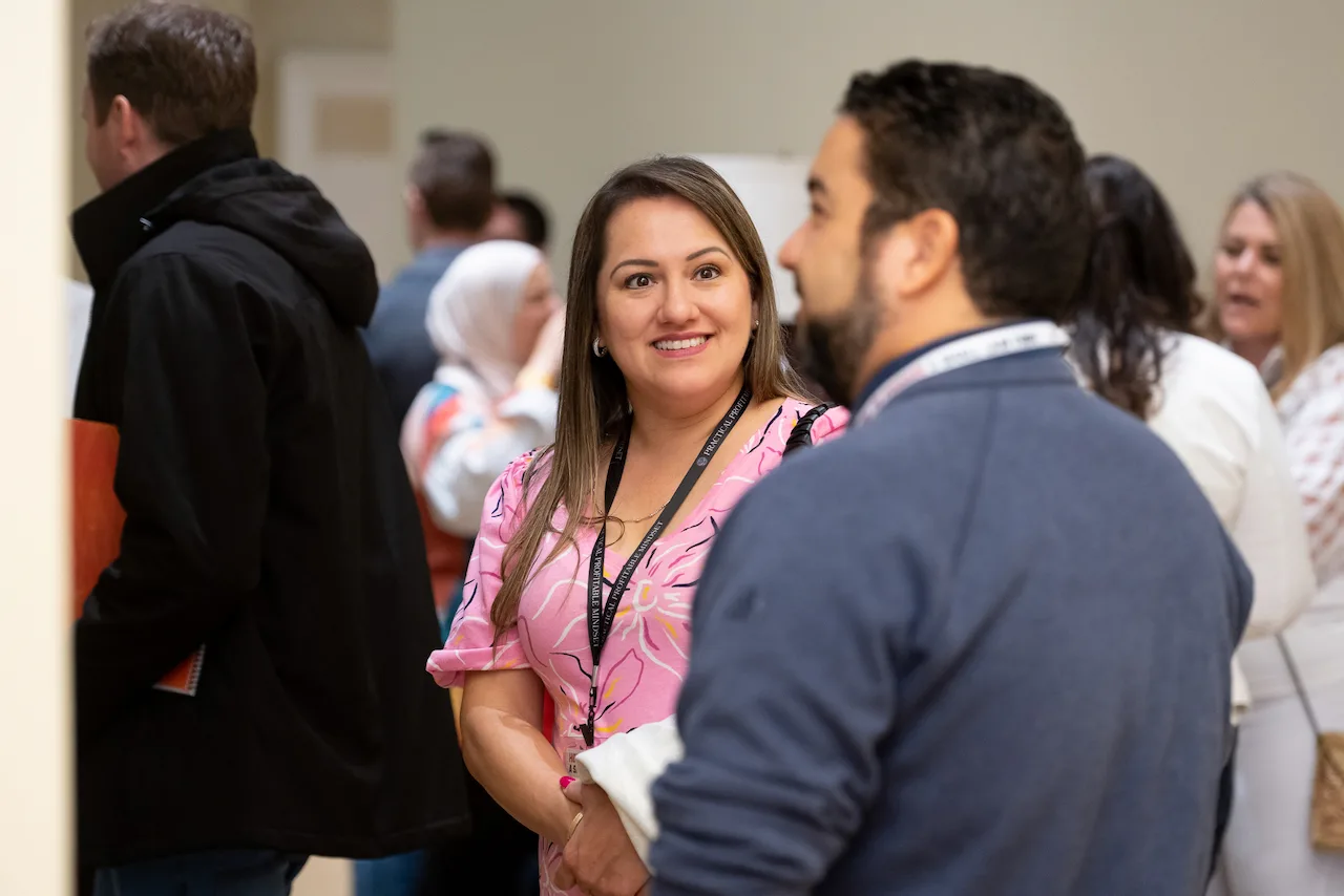 Members smiling and talking during an HTM networking break.