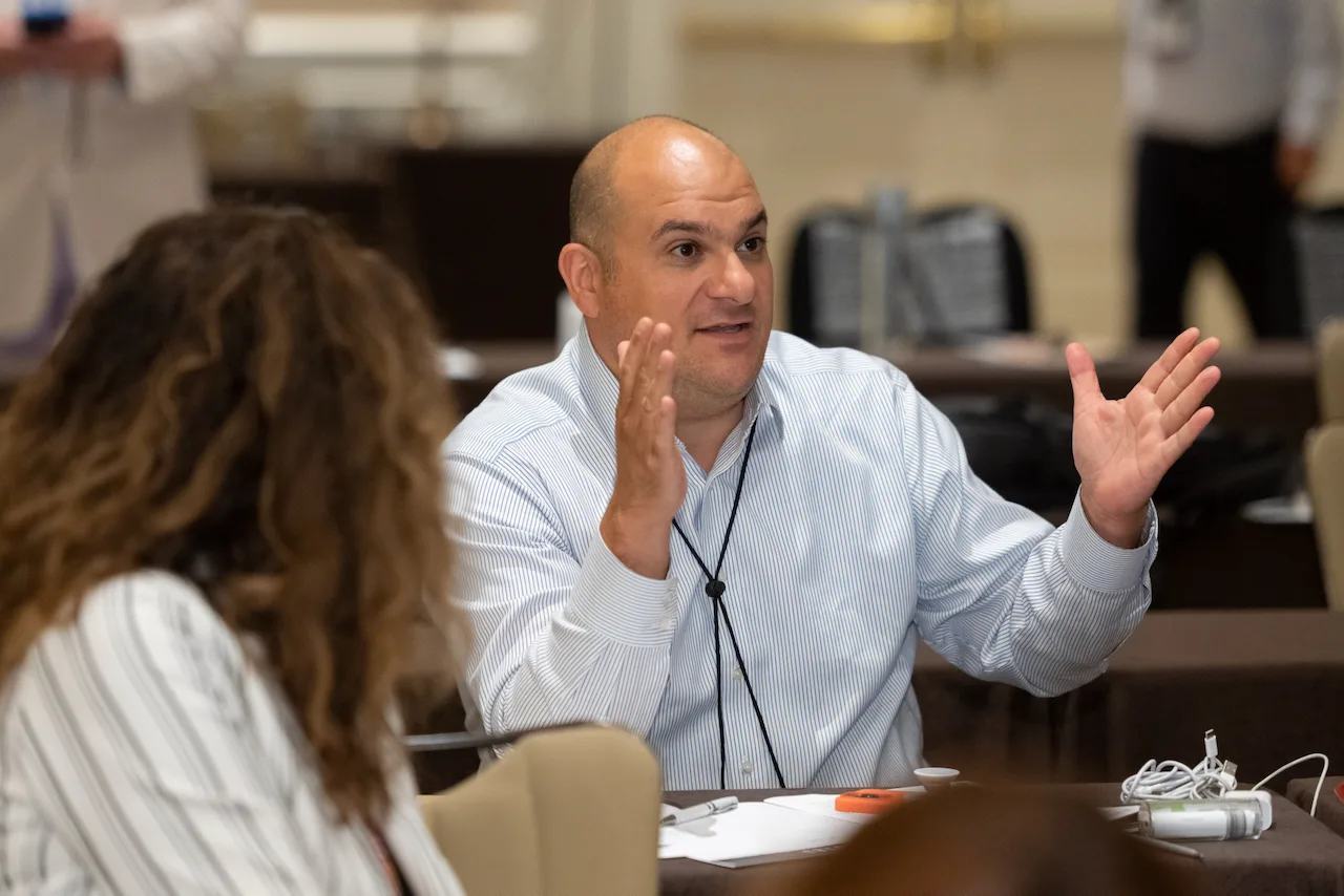 A law firm owner smiling during a thoughtful group conversation.