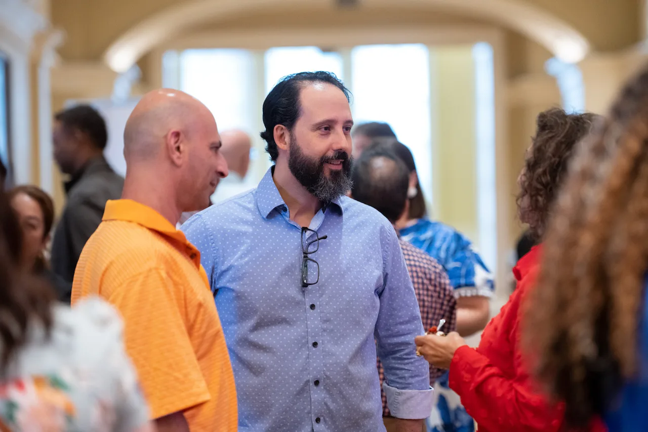 Law firm owners laughing together in a lively networking conversation.